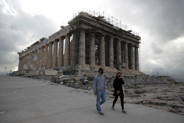 Los visitantes con máscaras faciales suben por la colina de la Acrópolis, con el Partenón de fondo en Atenas.  Archivo de imagen: AP Photo / Thanassis Stavrakis