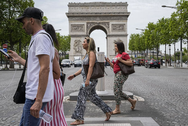 La gente cruza los Campos Elíseos en París el jueves.  El miércoles, Francia alivió varias restricciones de Covid.  Archivo de imagen: AP Photo / Michel Euler