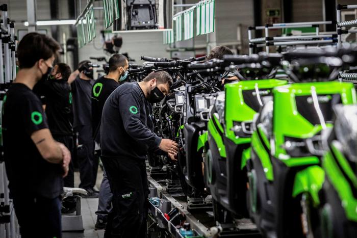 Trabajadores instalan componentes en motocicletas eléctricas S02 en una línea de montaje en la planta de Silence Urban Ecomobility en Barcelona